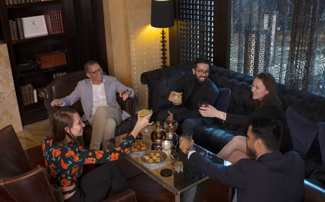 men enjoying a drink and cigars at a cigar lounge